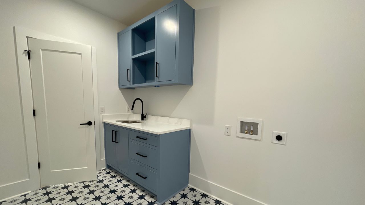 Entry-level laundry room by Six Points Homes